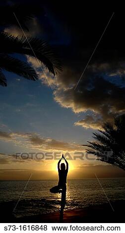 A young women practises the art of Yoga over a beautiful sunset at Tenerife beach View Large Photo Image Stock Photo - A young women practises the art of Yoga over a beautiful sunset at Tenerife beach. Fotosearch