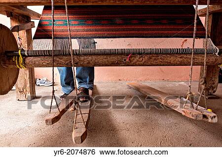 Stock Photograph - A Zapotec indigenous man uses a hand loom to weave traditional carpets October 30, 2013 in Teotitlan de Valle, Mexico.. Fotosearch