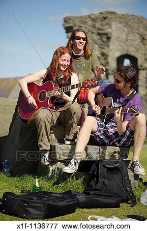 Aberystwyth university students playing guitars outdoors on a summer afternoon at the end of term after exams are finished, Wales UK View Large Photo Image Stock Photo - Aberystwyth university students playing guitars outdoors on a summer afternoon at the end of term after exams are finished, Wales UK. Fotosearch