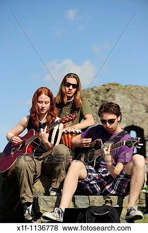 Stock Photo - Aberystwyth university students playing guitars outdoors on a summer afternoon at the end of term after exams are finished, Wales UK. Fotosearch