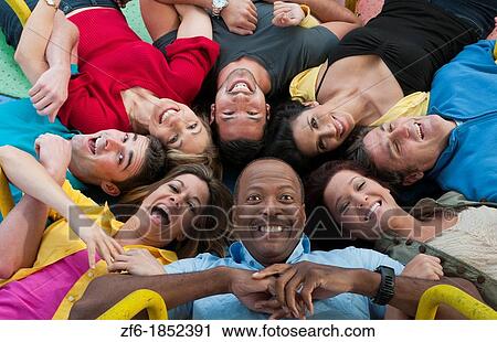 Stock Image - Abstract from above of many multi ethnic friends in playground laughing and sharing fun in spinning wheel of colors together. Fotosearch