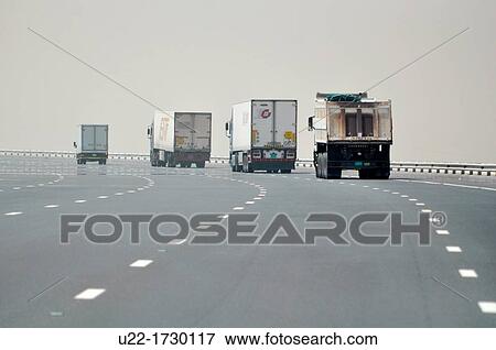 Abu Dhabi, United Arab Emirates: trucks along a road through the desert View Large Photo Image Stock Photo - Abu Dhabi, United Arab Emirates: trucks along a road through the desert. Fotosearch