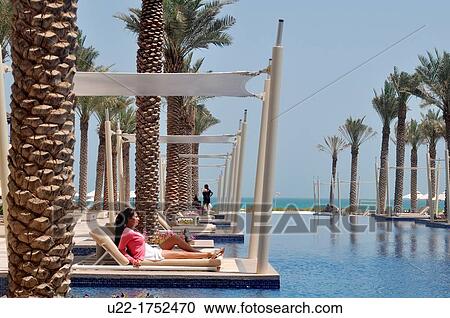 Stock Image - Abu Dhabi, United Arab Emirates: woman at the swimming pool of Hotel Park Hyatt Abu Dhabi, Saadiyat Island. Fotosearch