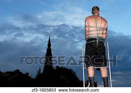 Acrobat tied with chains acting in Princes street of Edinburgh, infront of the scott monument, during the 2007 editon of the fringe festival View Large Photo Image Stock Image - Acrobat tied with chains acting in Princes street of Edinburgh, infront of the scott monument, during the 2007 editon of the fringe festival. Fotosearch