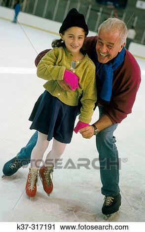 Active grandfather teaching his granddaughter how to skate on ice at skating rink View Large Photo Image Stock Image - Active grandfather teaching his granddaughter how to skate on ice at skating rink. Fotosearch