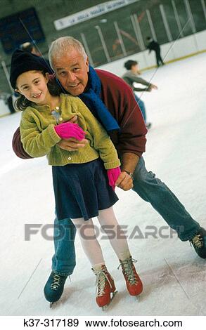 Active grandfather teaching his granddaughter how to ice skate at skating rink View Large Photo Image Stock Photo - Active grandfather teaching his granddaughter how to ice skate at skating rink. Fotosearch