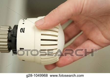 adjusting and lowering room temperature for energy economy on radiator thermostat View Large Photo Image Stock Photo - adjusting and lowering room temperature for energy economy on radiator thermostat. Fotosearch