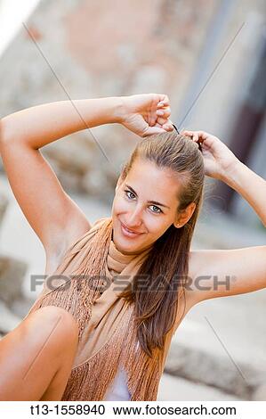 Adjusting hair on the street young woman View Large Photo Image Stock Image - Adjusting hair on the street young woman. Fotosearch