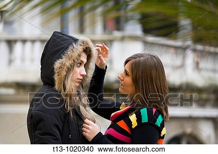 Adjusting her hood, two girlfriends View Large Photo Image Stock Image - Adjusting her hood, two girlfriends. Fotosearch