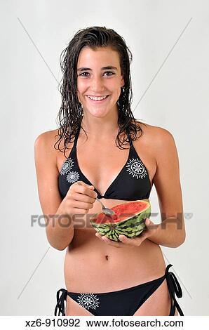 Stock Image - adolescent eating a watermelon spoons. Fotosearch