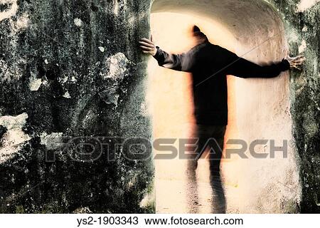 Adult male moving from darkness into light through portal He is holding on to the stone wall View Large Photo Image Stock Image - Adult male moving from darkness into light through portal He is holding on to the stone wall. Fotosearch