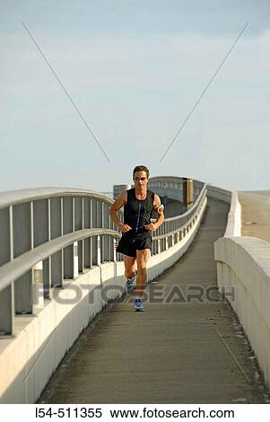 Adult male runs across a bridge in Jacksonville Florida for exercise and health. USA. View Large Photo Image Stock Photography - Adult male runs across a bridge in Jacksonville Florida for exercise and health. USA.. Fotosearch