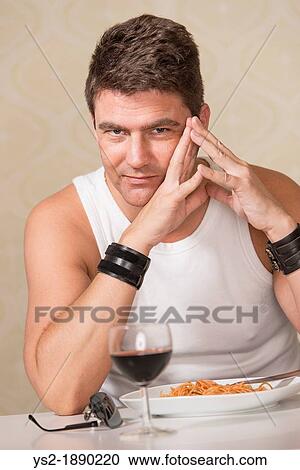 Adult male with casual clothes sitting by table with plate of pasta and glass of red wine View Large Photo Image Stock Image - Adult male with casual clothes sitting by table with plate of pasta and glass of red wine. Fotosearch