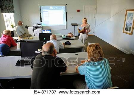 Adult Men and Women using technology in computer learning center View Large Photo Image Stock Photo - Adult Men and Women using technology in computer learning center. Fotosearch