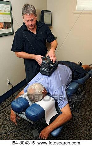 Stock Photography - Adult receiving chiropractor chiropratic treatment. Fotosearch