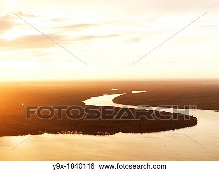 Aerial image of a tributary snaking through the jungle at sunset View Large Photo Image Stock Photograph - Aerial image of a tributary snaking through the jungle at sunset. Fotosearch