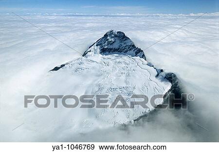 Aerial view of Mount Aspiring peak (3030m) and Bonar glacier emerging from a sea of white clouds. Mt Aspiring National Park, Otago, South island, New Zealand View Large Photo Image Stock Photo - Aerial view of Mount Aspiring peak (3030m) and Bonar glacier emerging from a sea of white clouds. Mt Aspiring National Park, Otago, South island, New Zealand. Fotosearch