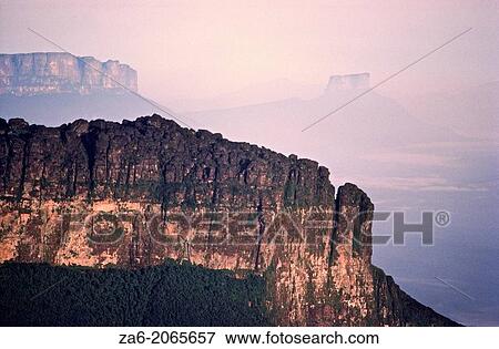Aerial view of the Southeastern wall at sunrise of Aparaman-tepuy in tne Gran Sabana, Auyantepuy and Wei-tepuy in the background. Canaima National Park, Bolivar State, Southern Venezuela. View Large Photo Image Stock Photo - Aerial view of the Southeastern wall at sunrise of Aparaman-tepuy in tne Gran Sabana, Auyantepuy and Wei-tepuy in the background. Canaima National Park, Bolivar State, Southern Venezuela.. Fotosearch