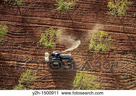 Stock Image - aerial view tractor spraying insecticide 2. Fotosearch