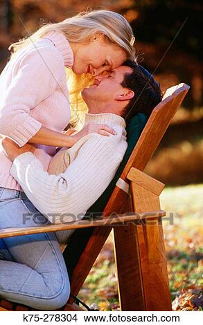 Picture - Affectionate couple in chair. Fotosearch