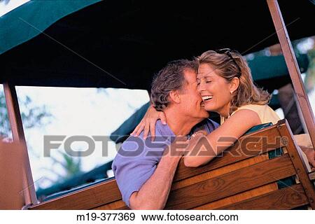 Stock Photo - affectionate couple on a swing. Fotosearch