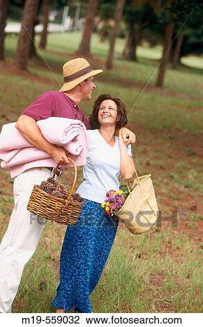 affectionate couple strolling to a picnic View Large Photo Image Stock Image - affectionate couple strolling to a picnic. Fotosearch