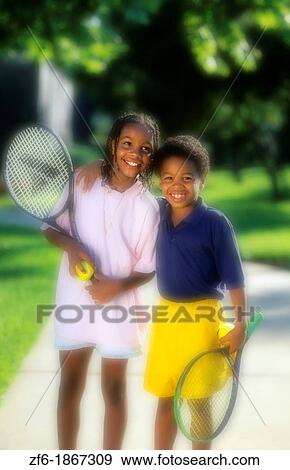 Affluent attractive young black african american youth aged 11 and 9 after competing at a game of tennis on walk View Large Photo Image Stock Photo - Affluent attractive young black african american youth aged 11 and 9 after competing at a game of tennis on walk. Fotosearch