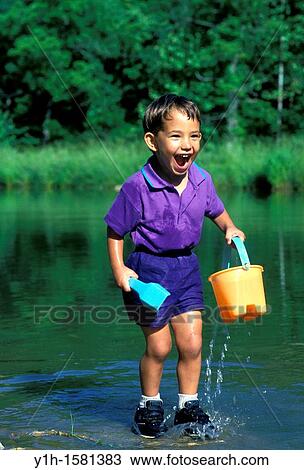 Afghan-American boy thrilled with water play in pond, summer, Midwest USA View Large Photo Image Stock Image - Afghan-American boy thrilled with water play in pond, summer, Midwest USA. Fotosearch