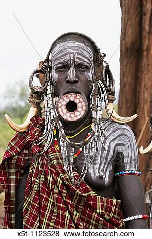 Stock Photo - Africa, Ethiopia, Debub Omo Zone, Mursi tribesmen A nomadic cattle herder ethnic group located in Southern Ethiopia, close to the Sudanese border Woman with clay lip disc as body ornaments. Fotosearch