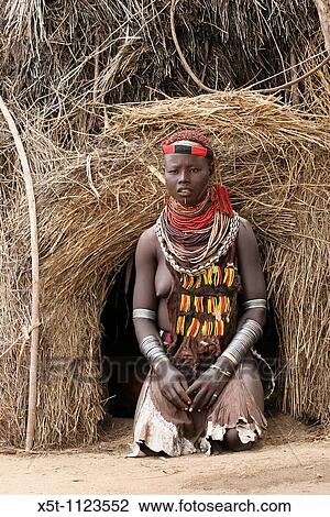 Stock Image - Africa, Ethiopia, Omo Valley, Daasanach tribe woman in front of hut. Fotosearch