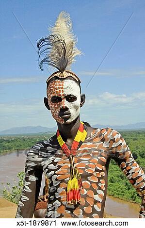 Stock Image - Africa, Ethiopia, Omo Valley, Konso tribe man in front of his thatch roof hut. Fotosearch