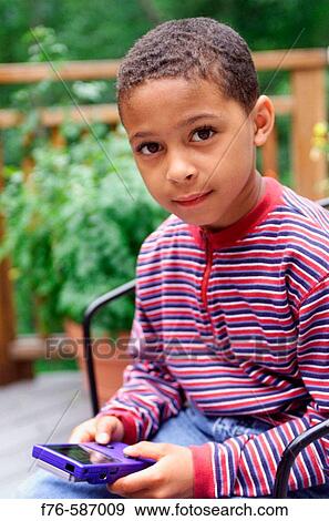 African American boy playing with hand held computer game View Large Photo Image Stock Photo - African American boy playing with hand held computer game. Fotosearch