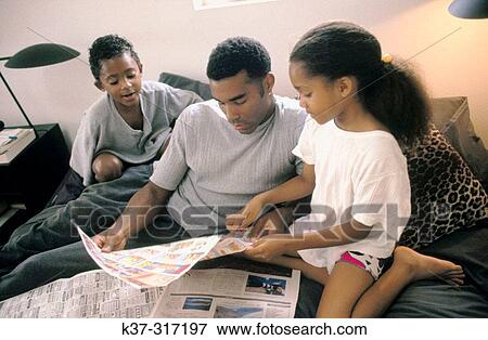 African-American father and children reading newspaper's comics View Large Photo Image Stock Photo - African-American father and children reading newspaper's comics. Fotosearch