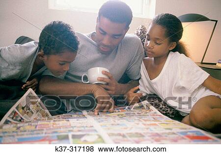 African-American father and children reading newspaper's comics View Large Photo Image Stock Photo - African-American father and children reading newspaper's comics. Fotosearch