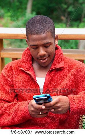 African American teenage boy playing with hand held computer game. View Large Photo Image Stock Photo - African American teenage boy playing with hand held computer game.. Fotosearch