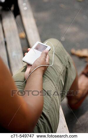 African-American woman holding ipod on park bench View Large Photo Image Stock Photo - African-American woman holding ipod on park bench. Fotosearch