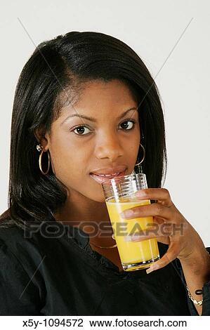 African American Woman in early 20's drinking orange juice View Large Photo Image Stock Image - African American Woman in early 20's drinking orange juice. Fotosearch