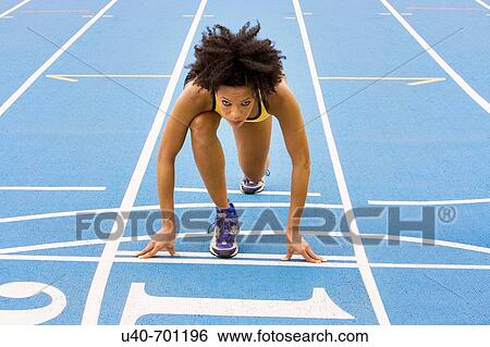 Stock Photograph - African American woman running track. Fotosearch
