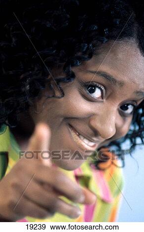 African-American woman smiling and looking and pointing at the camera View Large Photo Image Stock Photo - African-American woman smiling and looking and pointing at the camera. Fotosearch