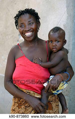 African mother carrying her baby boy on her arm, Ilha de Mocambique ...