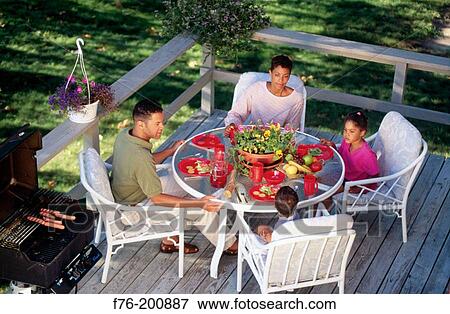Afro-american family eating outdoors in deck View Large Photo Image Stock Photo - Afro-american family eating outdoors in deck. Fotosearch