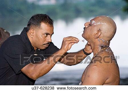 Stock Photo - After shaving then cleansing the body by the river before the Thaipusam Festival. Fotosearch