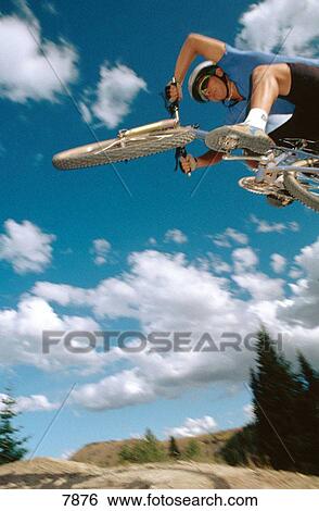 Aggressive mountain biker jumping into the sky View Large Photo Image Stock Photograph - Aggressive mountain biker jumping into the sky. Fotosearch