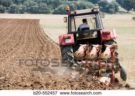 Agricultural machinery. Tractor ploughing the land. Mouldboard plough. Harvesting of cereals, Oco (near Estella), Navarre, Spain View Large Photo Image Stock Photo - Agricultural machinery. Tractor ploughing the land. Mouldboard plough. Harvesting of cereals, Oco (near Estella), Navarre, Spain. Fotosearch