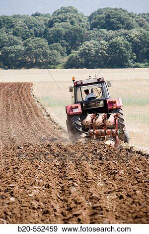 Agricultural machinery. Tractor ploughing the land. Mouldboard plough. Harvesting of cereals, Oco (near Estella), Navarre, Spain View Large Photo Image Stock Photo - Agricultural machinery. Tractor ploughing the land. Mouldboard plough. Harvesting of cereals, Oco (near Estella), Navarre, Spain. Fotosearch