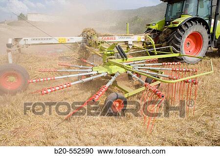 Stock Image - Agricultural machinery. Windrower. Harvesting of cereals,? Learza? estate. Near Estella, Navarre, Spain. Fotosearch