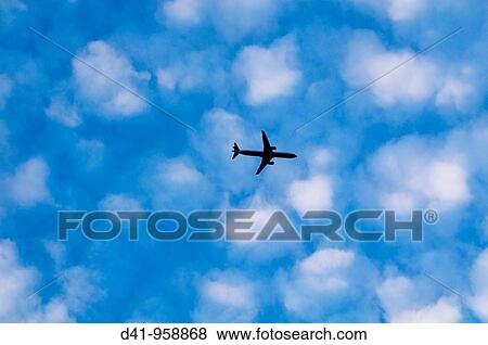 Stock Photo - airliner flying through clouds cottonwool. Fotosearch