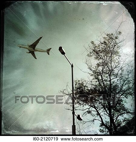 Stock Photo - Airplane contrails against blue sky, Madrid, Spain.. Fotosearch
