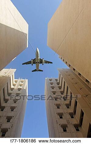 Stock Photograph - Airplane flying over a Building, Pune, Maharashtra, India. Fotosearch