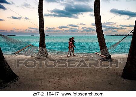 Aitutaki. Cook Island. Polynesia. South Pacific Ocean. Two tourists walk along the beach of the Hotel Aitutaki Lagoon Resort & Spa. View Large Photo Image Stock Photo - Aitutaki. Cook Island. Polynesia. South Pacific Ocean. Two tourists walk along the beach of the Hotel Aitutaki Lagoon Resort & Spa.. Fotosearch